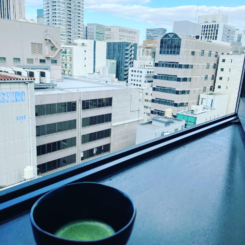オフィスの窓辺に抹茶をいれた茶碗をおいた画像です。