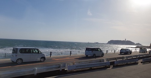 江ノ電から見た海岸と海岸沿いを走る車の列