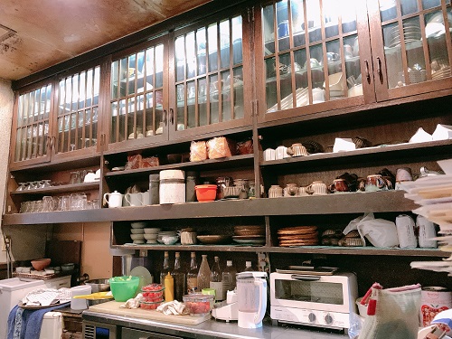 アンテークな茶箪笥に食器などが並べられているカフェの厨房。