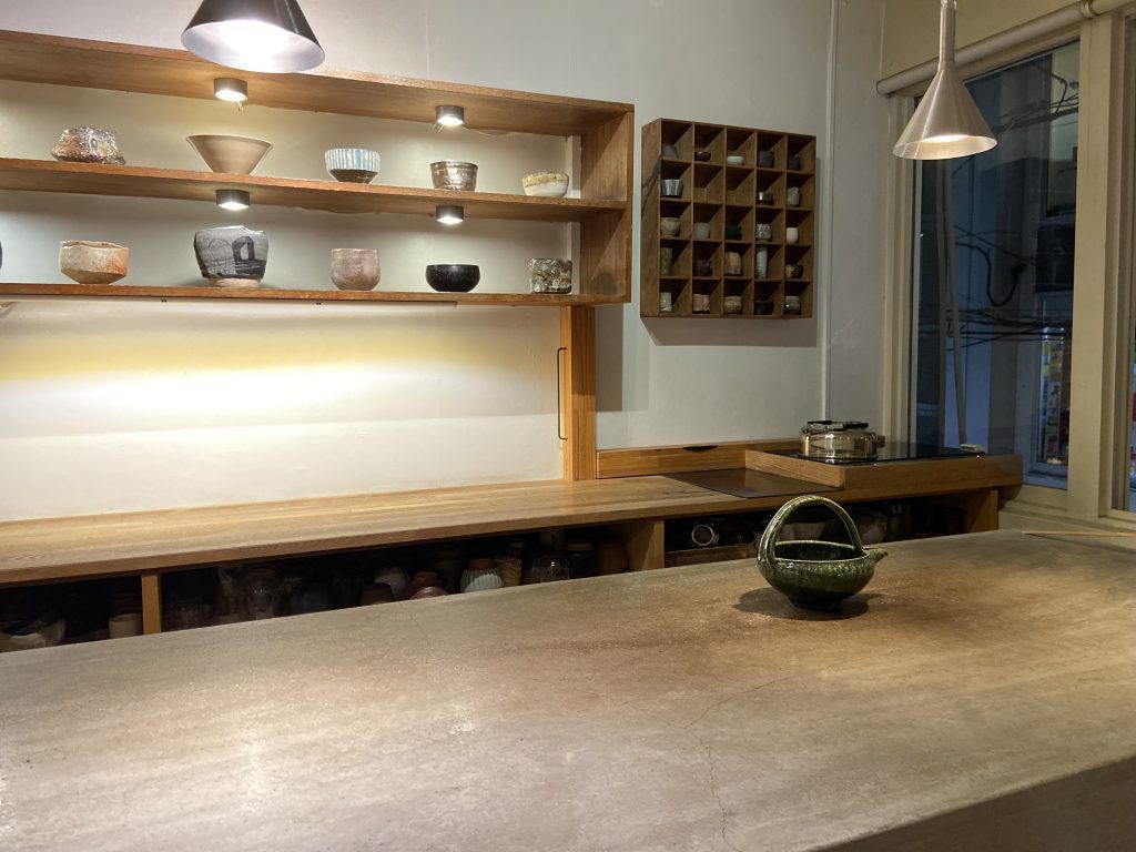 wad omotenashi cafeさんの店内で、カウンターが手前にあり、壁には抹茶茶碗が色々並んでいます。お抹茶を頼むと好きな茶碗にいれて頂けます。