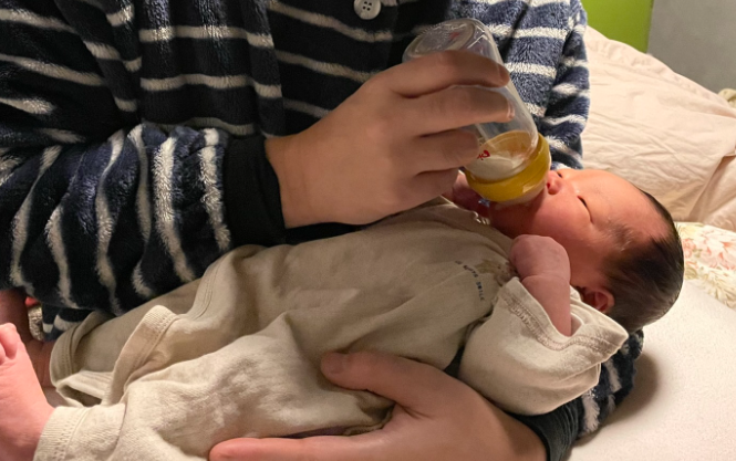 パパが哺乳瓶で赤ちゃんに授乳している写真