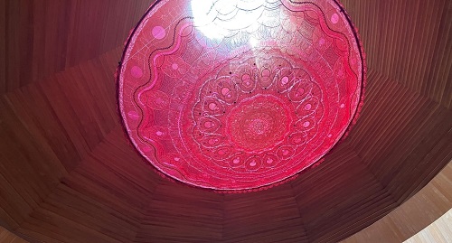 ヒノキの木製のタワー内。赤い円形のモチーフが天井に付いている。